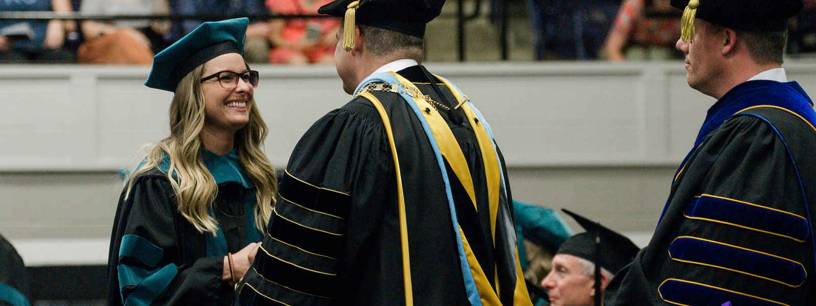 physical therapy student receives diploma at commencement ceremony
